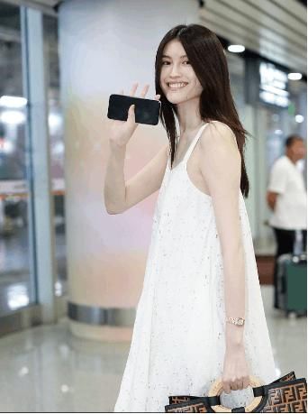 何穗一身白裙亮相机场，长发飘飘，气质动人，校园女神无疑了