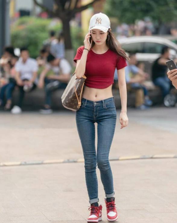 黑色低胸裙美女，低头走路的样子气质十足，掩饰不住她魔鬼身材