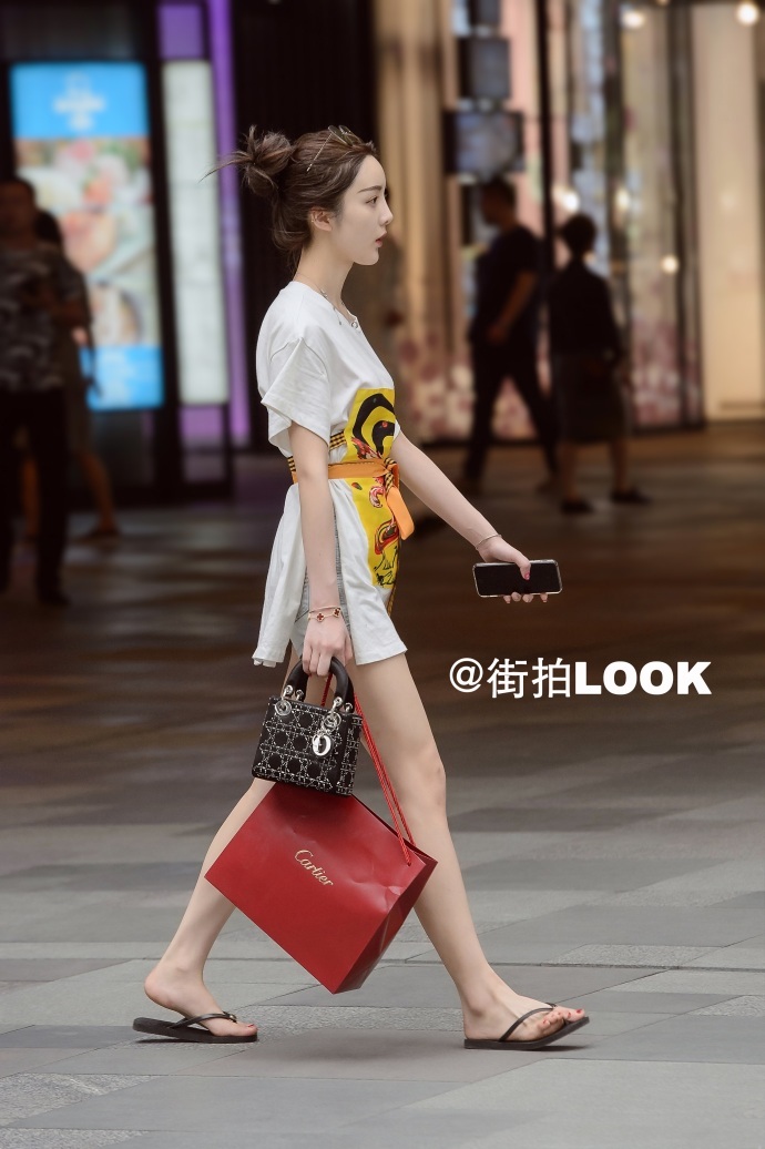 路人街拍：黑T恤搭牛仔短裤秀出美丽长腿，小姐姐边走边听歌