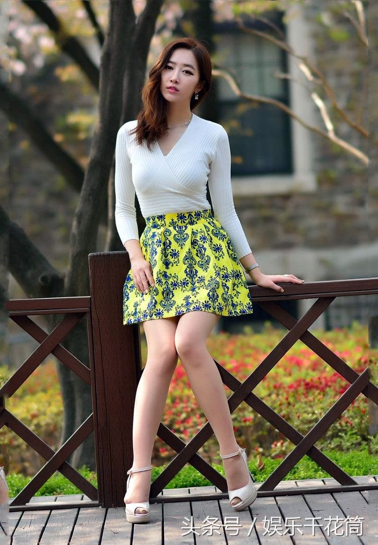 模特穿印花裙子少女感满满，坐路边栏杆心情很微妙