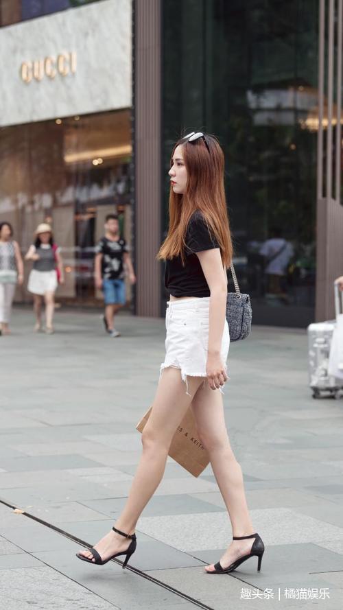 路人街拍，小姐姐穿吊带衫配紧身牛仔裤，身姿靓丽，气质出众！