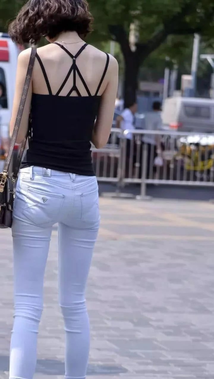 街拍紧紧身牛仔裤小姐姐，白色紧致的背影走在街上赚足眼球