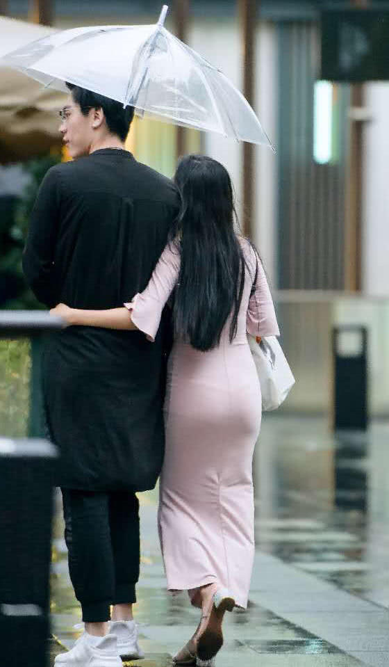 气质小姐姐和男友雨中漫步秀恩爱，包臀裙裹出了丰满的臀线