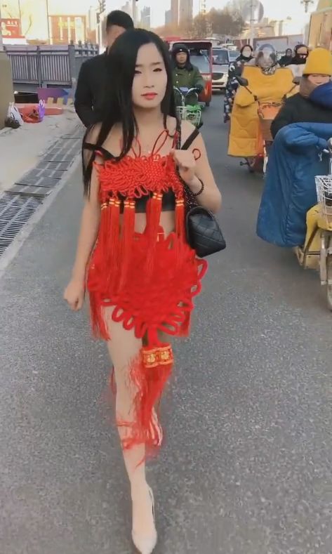 美女披着中国结衣服走在街头，路人表示大开眼界