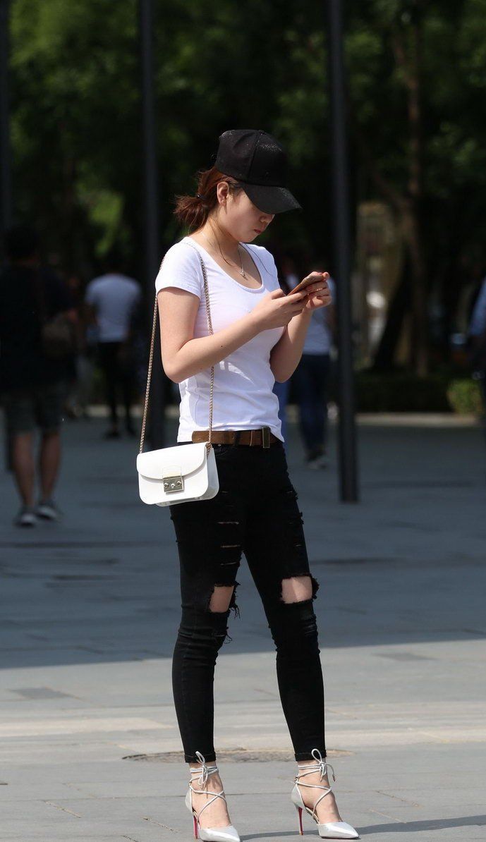 环城公园街拍:破洞牛仔裤美女，展现出成熟稳重的气质