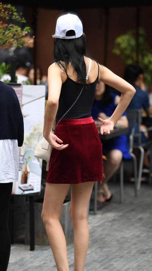 小姐姐身材非常的高挑，上边一件黑色吊带上衣，散发迷人的魅力。