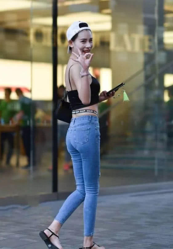 可爱萌妹吊带背心勾勒出凹凸有致的曲线，清爽效果极佳，破洞牛仔