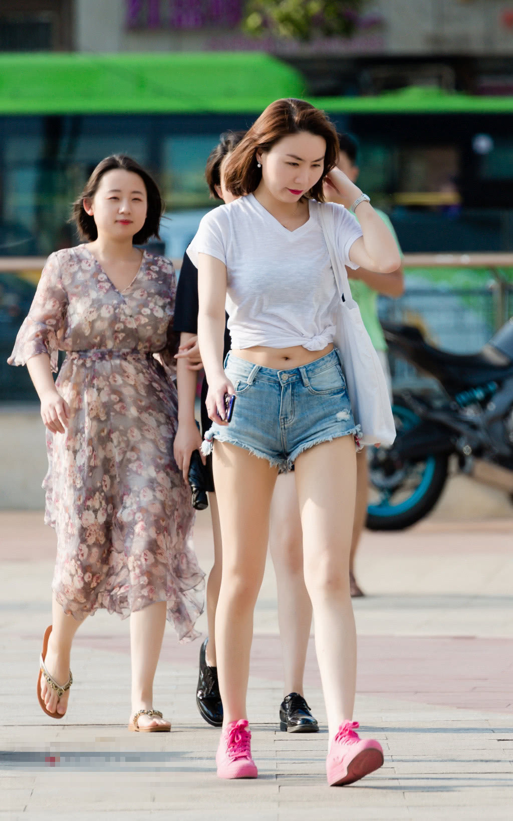 小姐姐白色的V领T,在腰部做了一个结，露脐的设计也是静静的性感