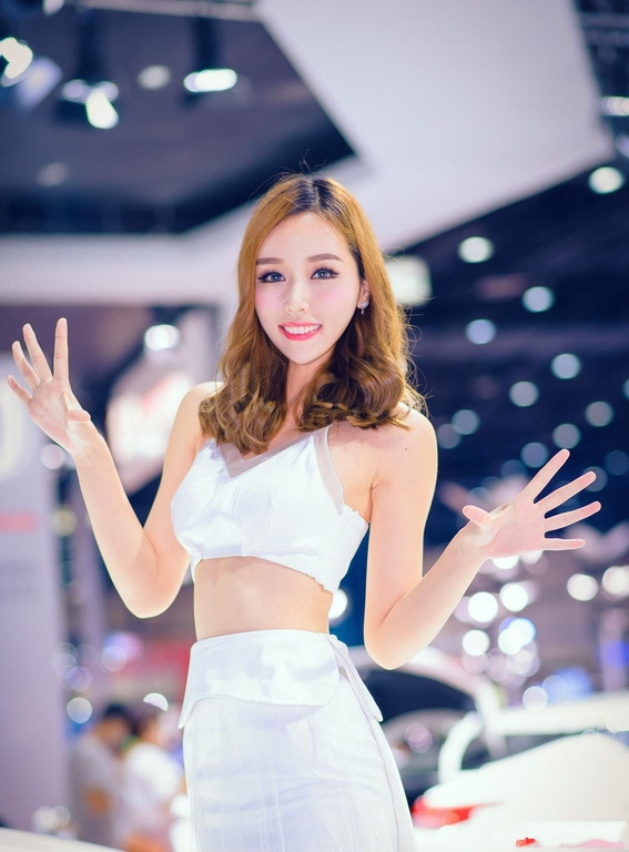 明艳娇俏的美女车模，白色纱裙自带满满仙气，笑容甜美引全场瞩目