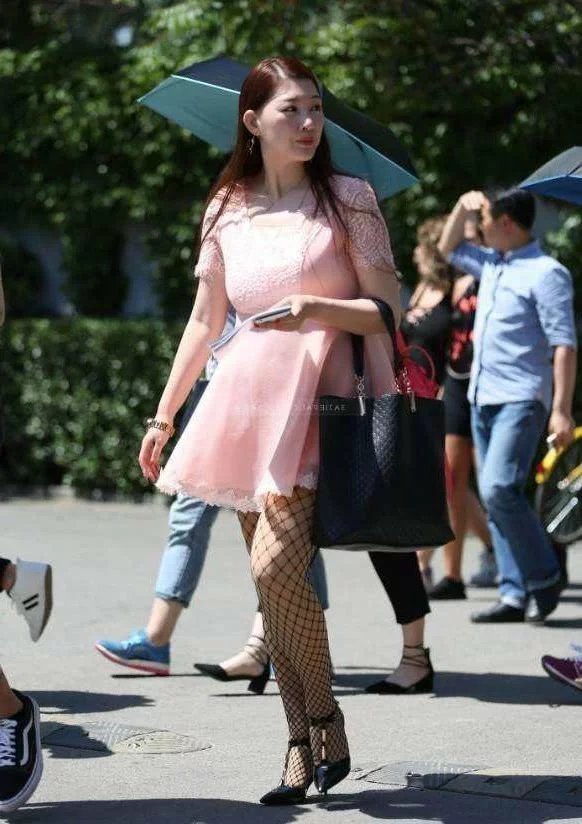 小姐姐粉色连衣裙搭配渔网袜显凹凸有致身材，下身黑色渔网袜成为