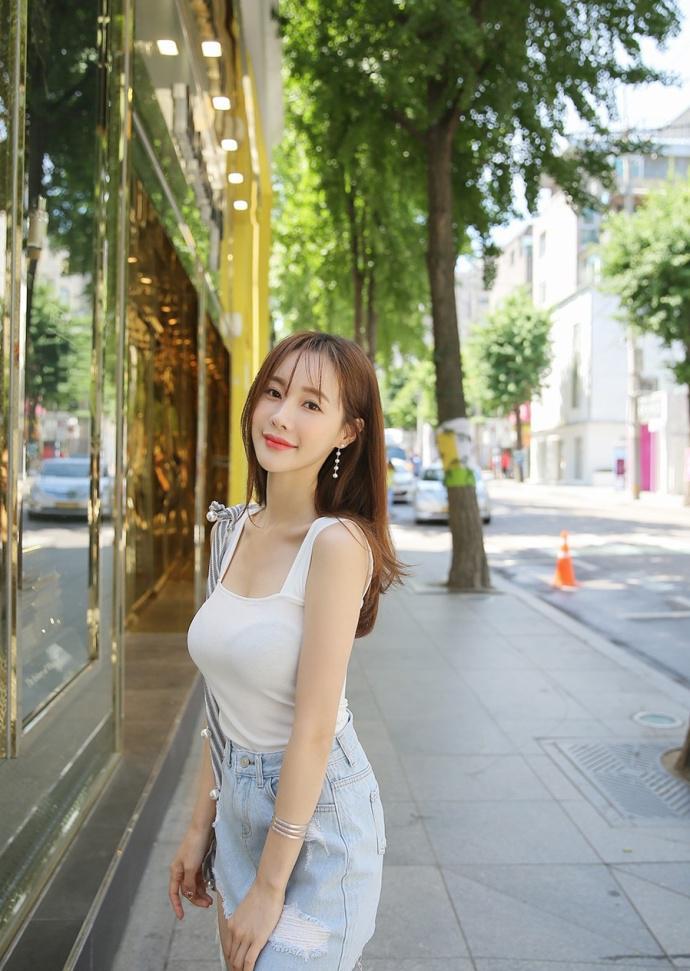 路人街拍，小姐姐牛仔短裙搭配白色吊带衫，简直是甜美到没朋友