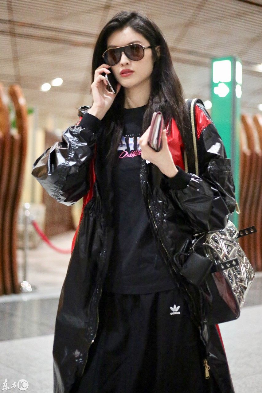 超模何穗现身北京机场，一身雨衣，难掩美腿