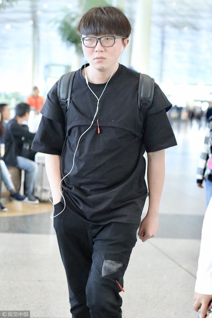 毛不易全黑look扮酷机场边走边听歌 “苹果脸”配“西瓜头”自带