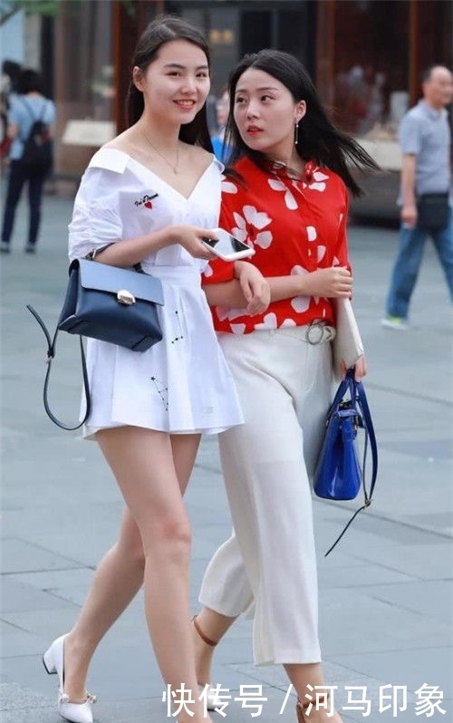 蓝色|街拍:小姐姐身穿白色的牛仔裤,搭配件蓝色的休闲上衣,看上去更加的完美秀气