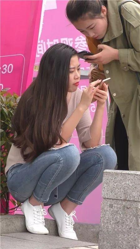 街拍美女：在街边等车的紧牛长发俏丽美女