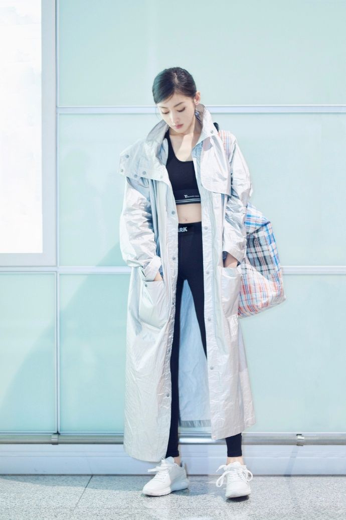 张天爱现身机场 黑色紧身裤外搭银色长款雨衣 尽显大长腿
