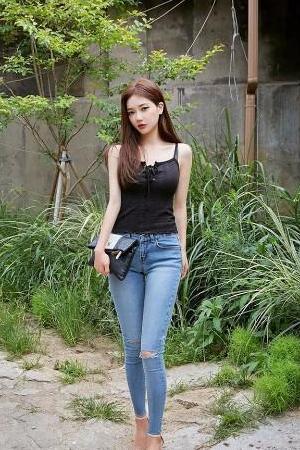 清新美女身穿吊带背心搭配牛仔裤，秀出漂亮的身材，非常有女人味