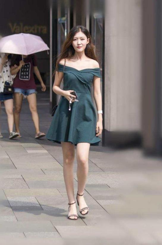 路人街拍，小姐姐身穿黑色紧身的低领露脐的短袖，很有视觉冲击力