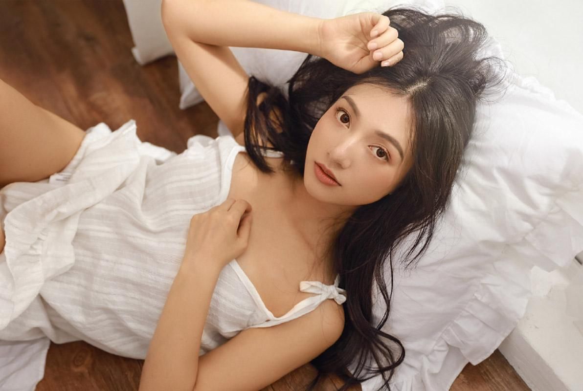 吊带裙美女性感慵懒床上写真图片