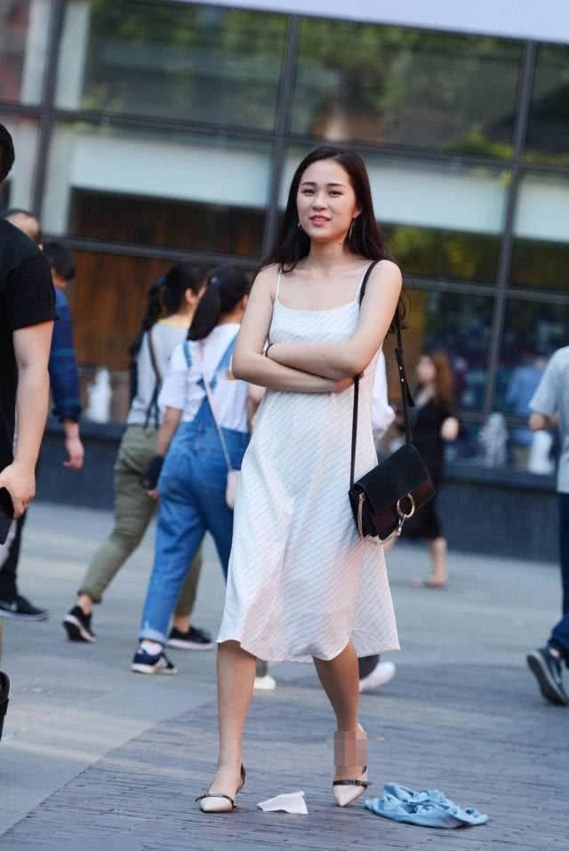 街拍美女:气质小姐姐吊带连衣裙秀白皙美腿，优雅的弯腰吸睛无数