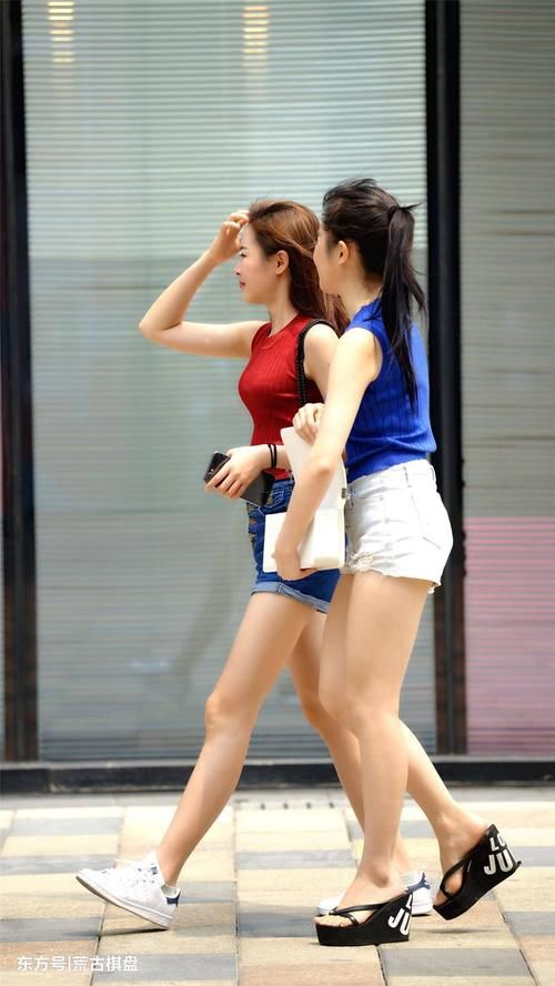 两位穿着热裤的姐姐虽然搭配色彩不同，但是更像是一对双胞胎姐妹