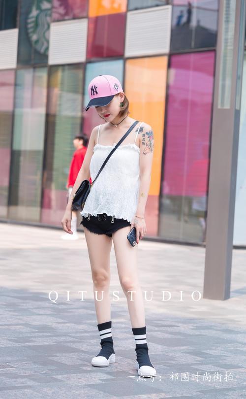 北京街拍:小姐姐身穿黑色性感热裤,头戴粉色棒球帽,个性十足。