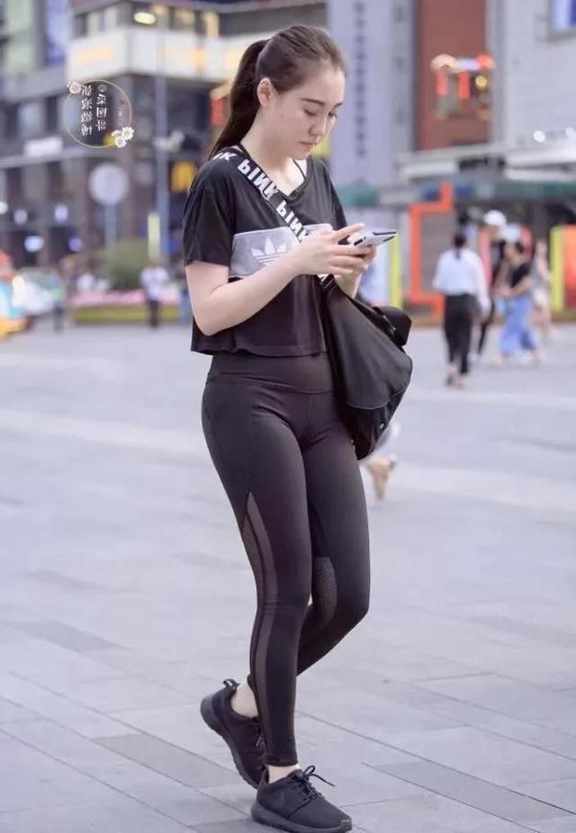 紧身裤小辣妹显凹凸线条，低头玩手机成了一道时尚风景线