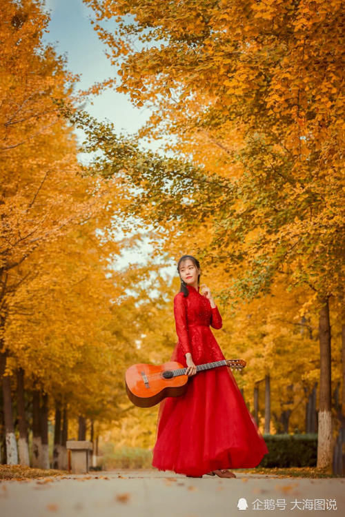 身着红裙怀抱吉他，徜徉在美丽的秋天里！