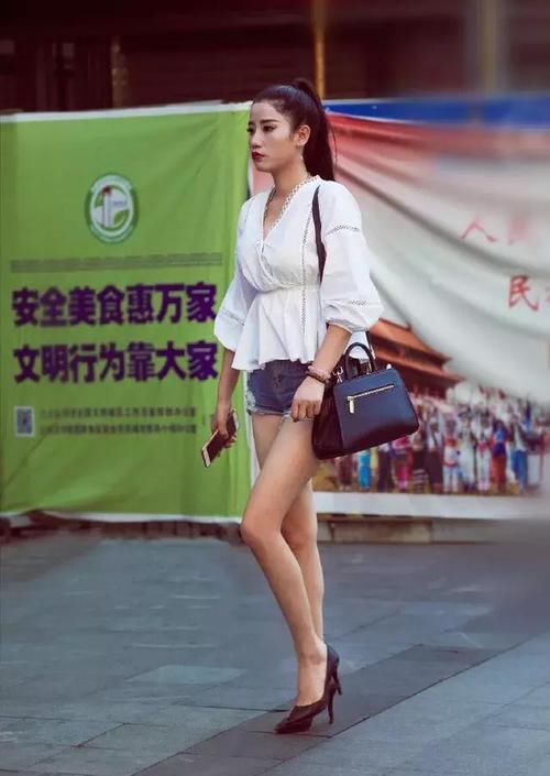  [搭配一双]街拍：小姐姐上衣采用了大V领的设计，非常的显脸小，显气质