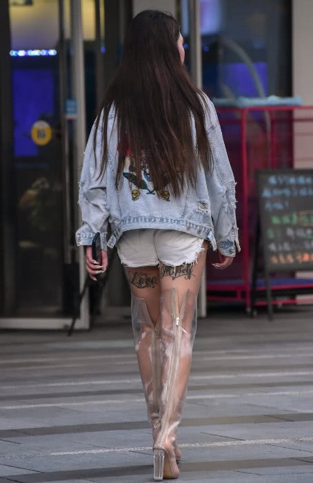 时尚小姐姐火辣出行，牛仔短裤尽显筷子腿，大腿根处布满了纹身