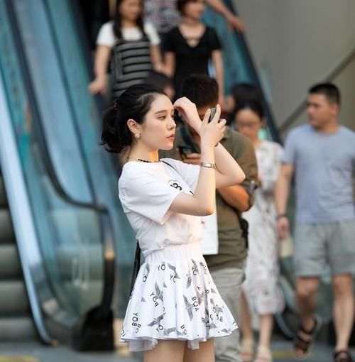  [动人]路人街拍，白色的上衣搭配一条非常可爱俏皮的短裙，真是气质动人