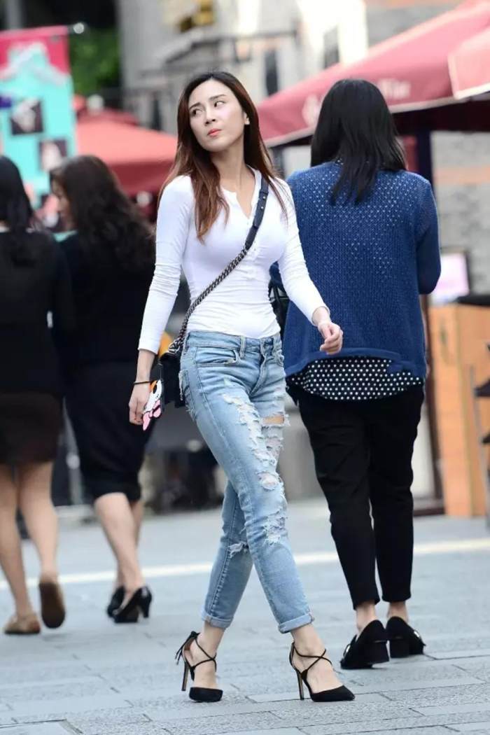 街拍: 破洞紧身牛仔裤美女, 肚子上没有一点肚腩, 上身有点藏不住