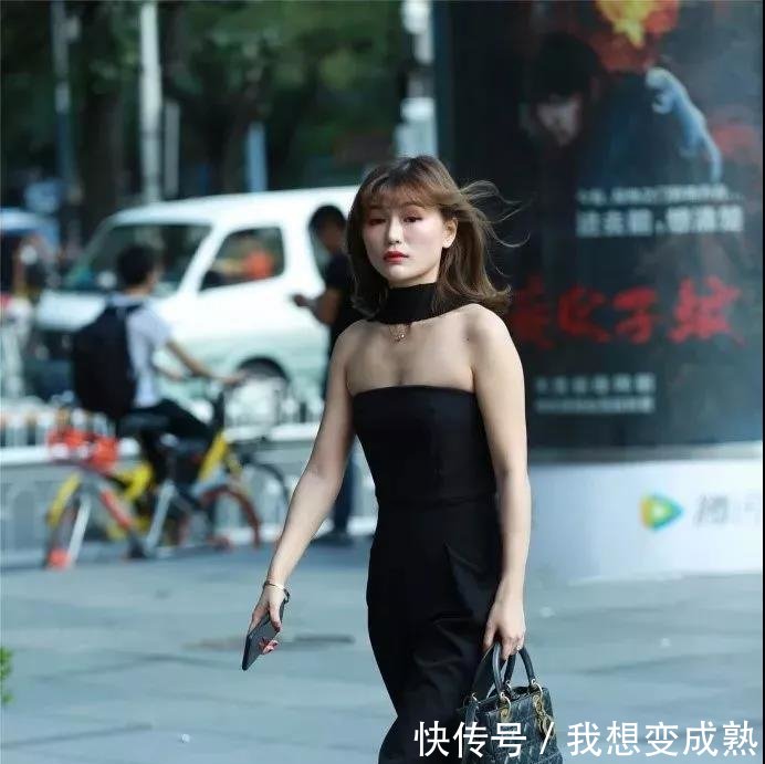 路人街拍，皮肤白皙的美女穿露脐装配紧身牛仔裤，身材妩媚而性感