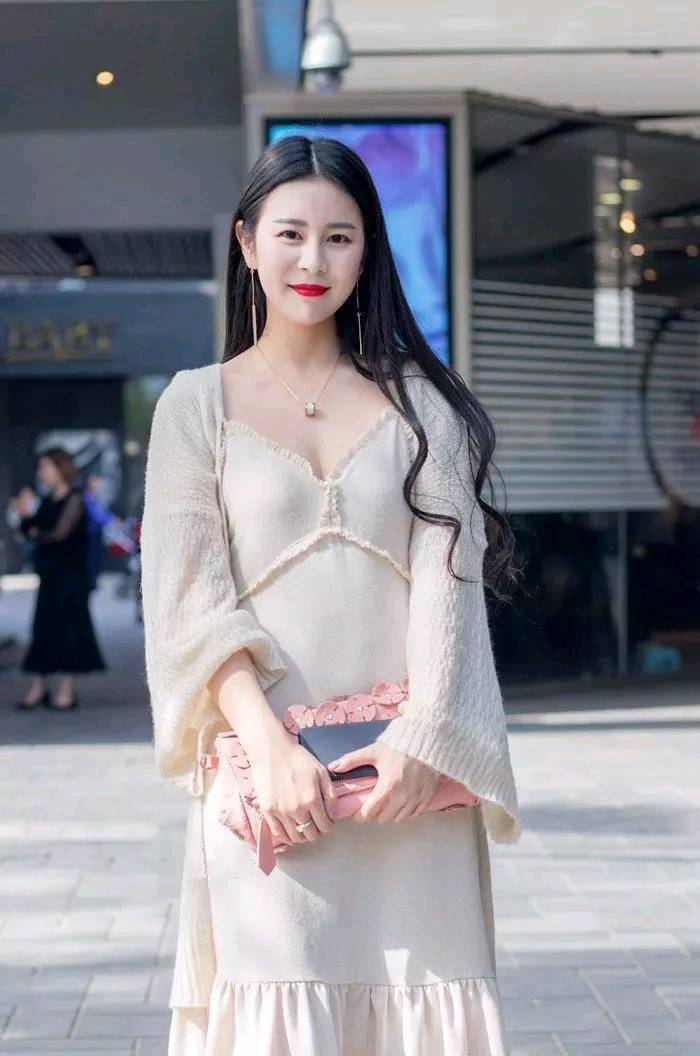 黑色低胸裙美女，低头走路的样子气质十足，掩饰不住她魔鬼身材