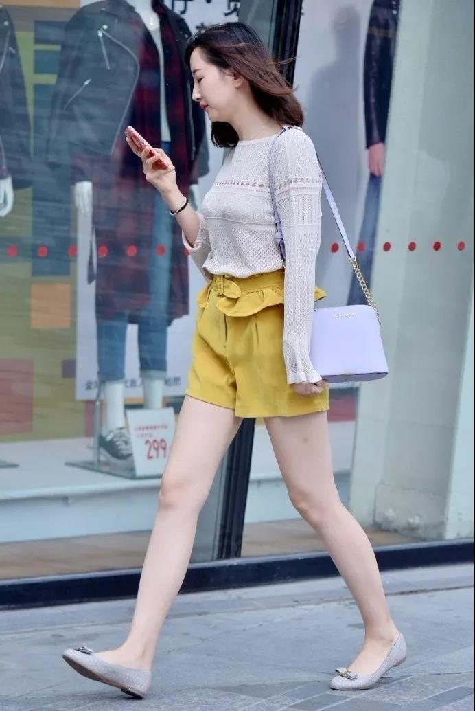 街拍：肤色白皙穿黄色短裤的年轻靓丽性感美女