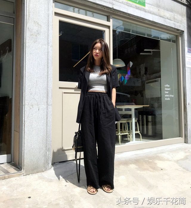 模特一袭灰色T恤配黑色阔腿裤简约时尚，气质清冷不苟言笑