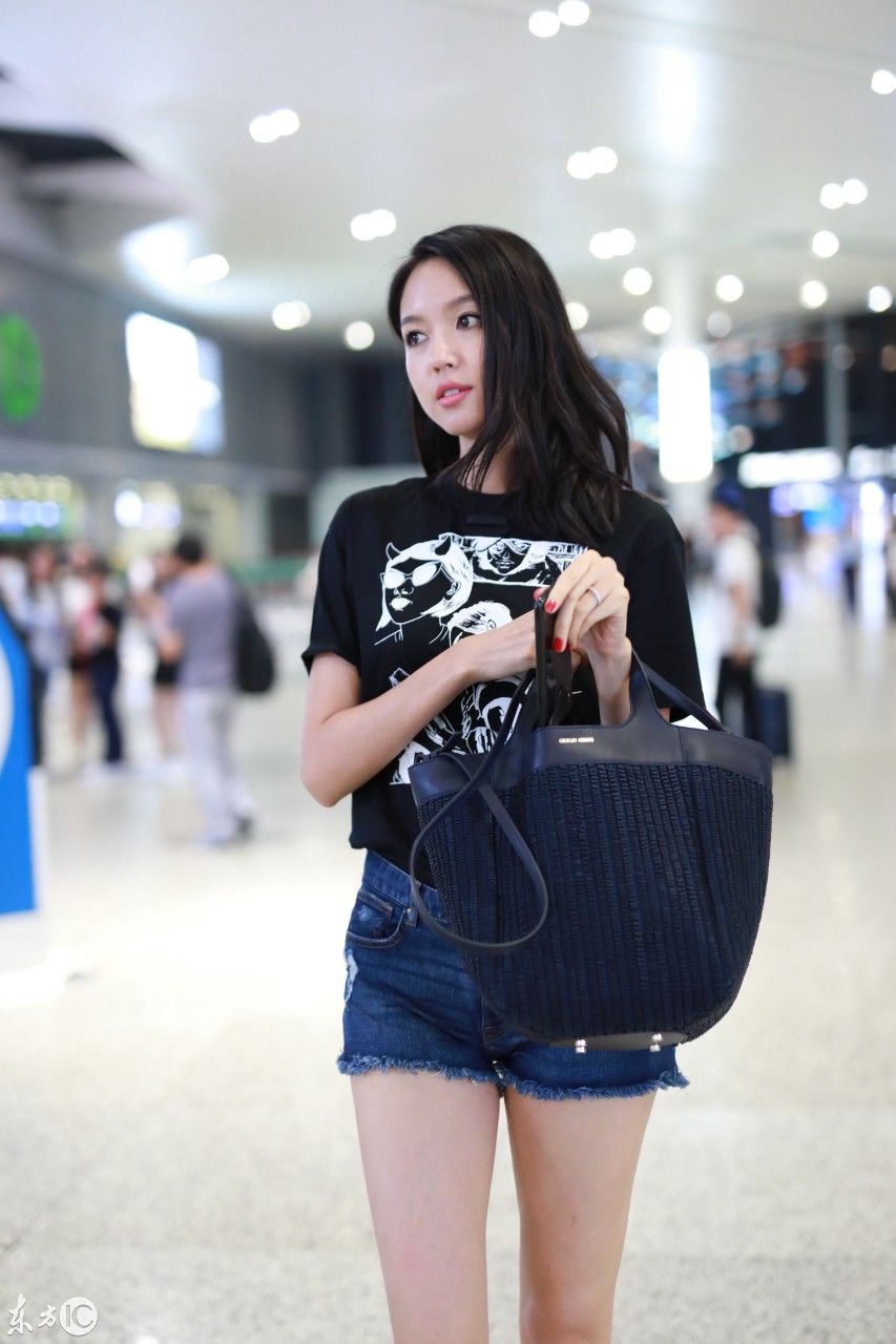 张梓琳穿黑色T恤搭配蓝色牛仔短裤现身机场，皮肤白皙秀大长腿