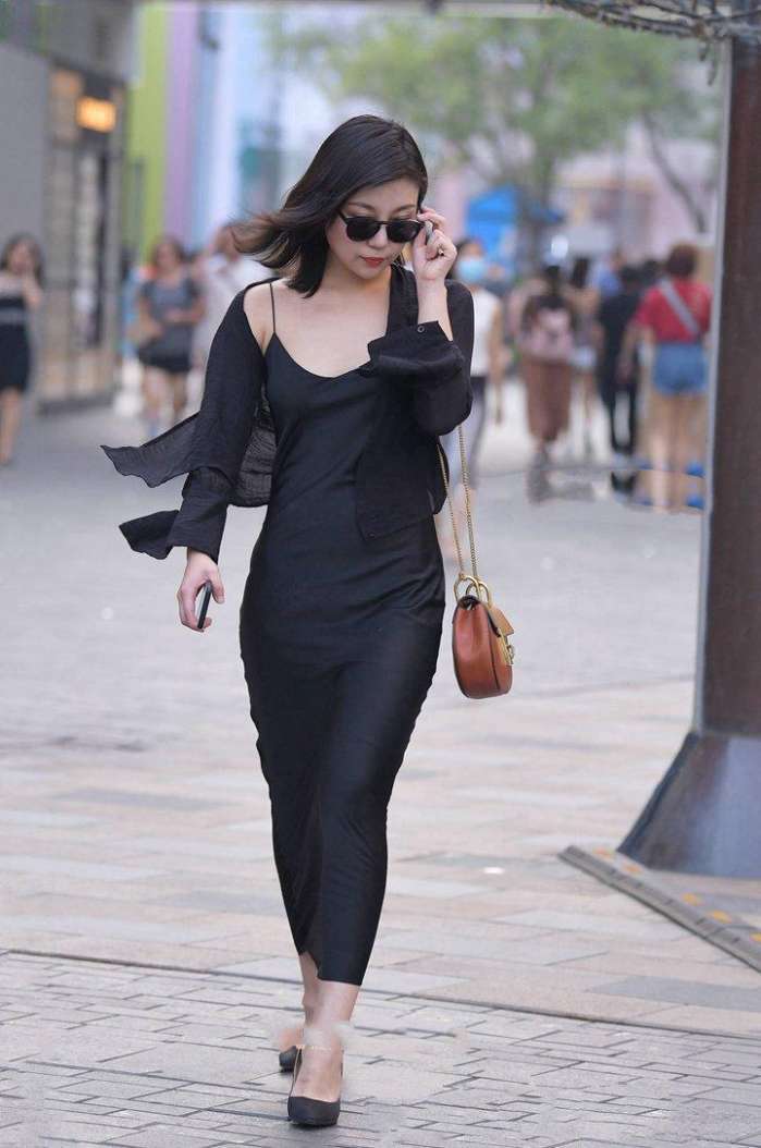 美女深色打扮, 透露出婀娜多姿的身段, 举手投足尽显魅力