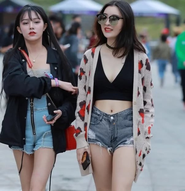 逛街时尚姐妹花小姐姐牛仔短裤穿出不同风格,摇摆的身姿吸睛无数