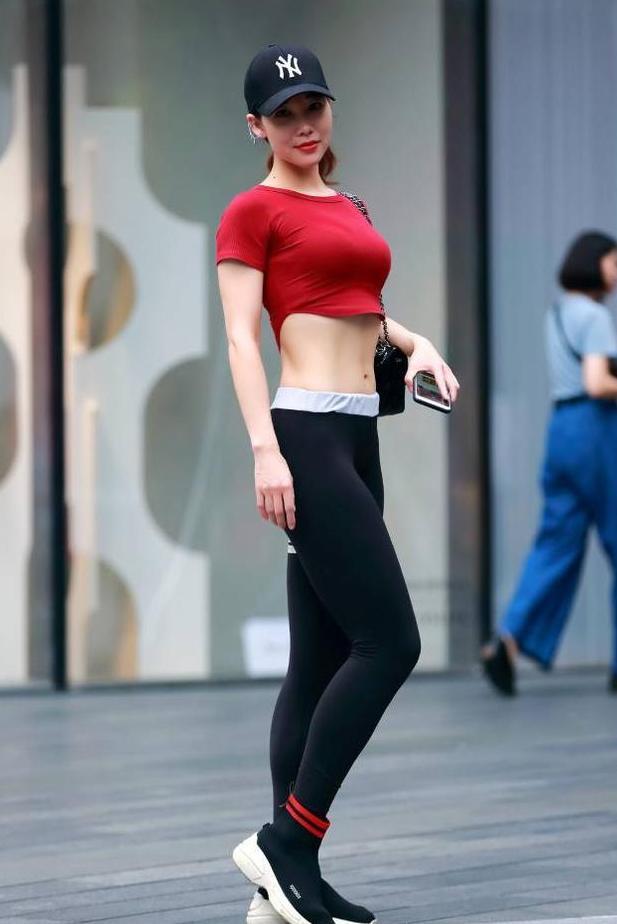 修边的黑色打底裤更塑臀的曲线美，再穿上肚脐T恤很有整体美感！