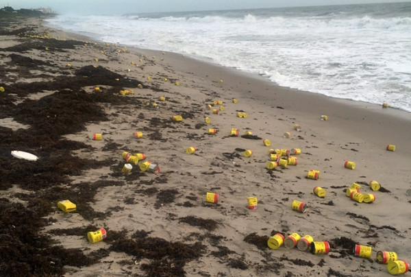 男子在沙滩游玩,海里冲上来许多黄色罐子,引来附近居民疯狂捡拾