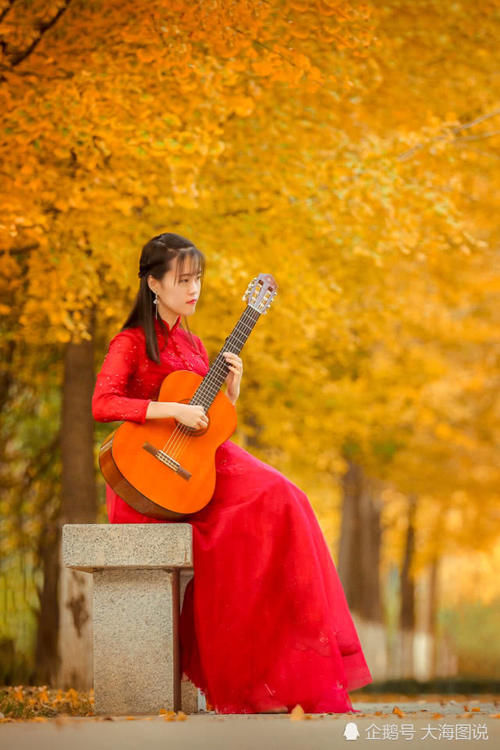 身着红裙怀抱吉他，徜徉在美丽的秋天里！
