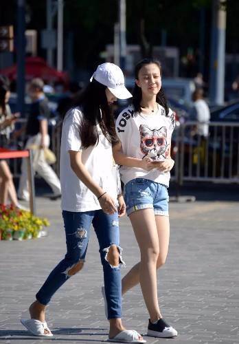 路人街拍，美女身材火辣，穿吊带衫搭配紧身裤别有一番风情！