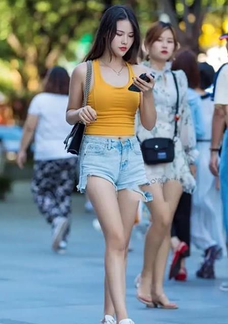  『美女』美女时尚街拍：身材高挑的美女，一件橙色背心配牛仔短裤，青春活力气质范