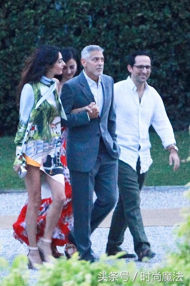 阿马尔克鲁尼穿着橙色短裤，与丈夫乔治一起在科莫湖共进晚餐