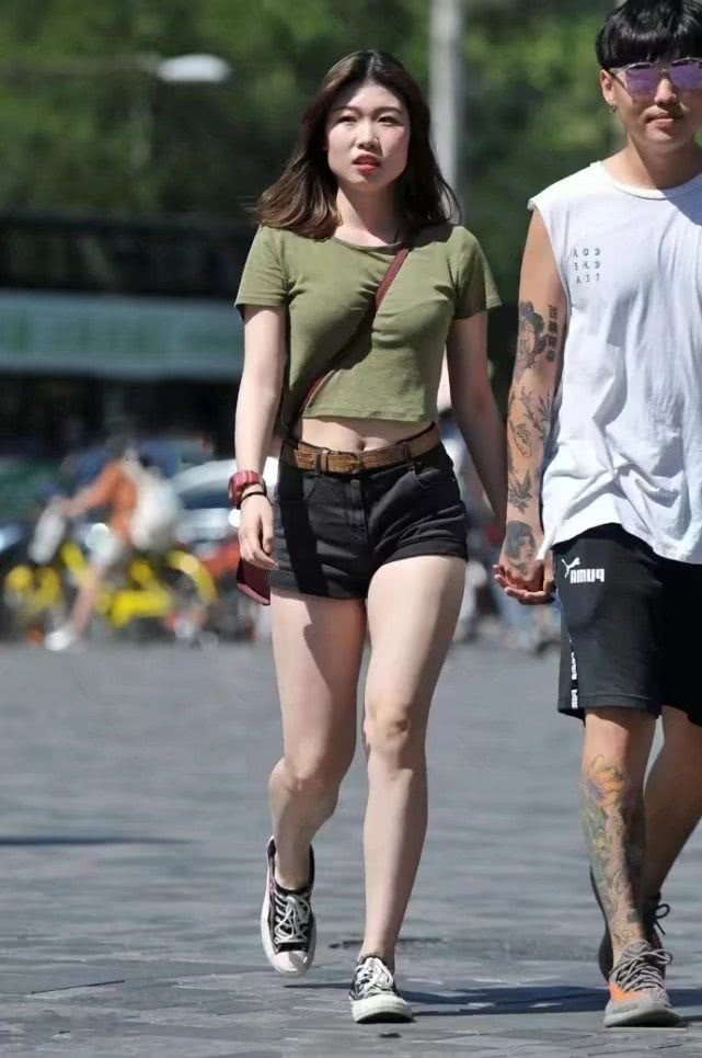 气质小姐姐紧身短裤尽显肥硕大腿，和小十岁男友牵手缠绵不顾路人