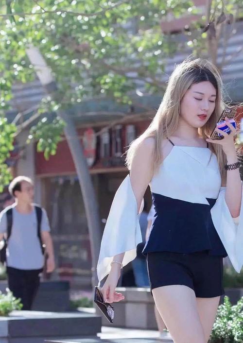 性感小姐姐身穿露背装搭配黑色超短裤，大秀美背十分性感