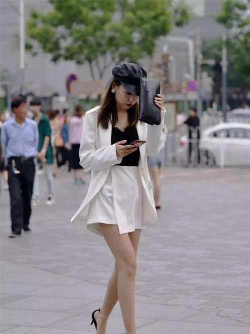  『尽显』街拍：小姐姐一件米白色的短裙，搭配黑色小衫，尽显时尚魅力