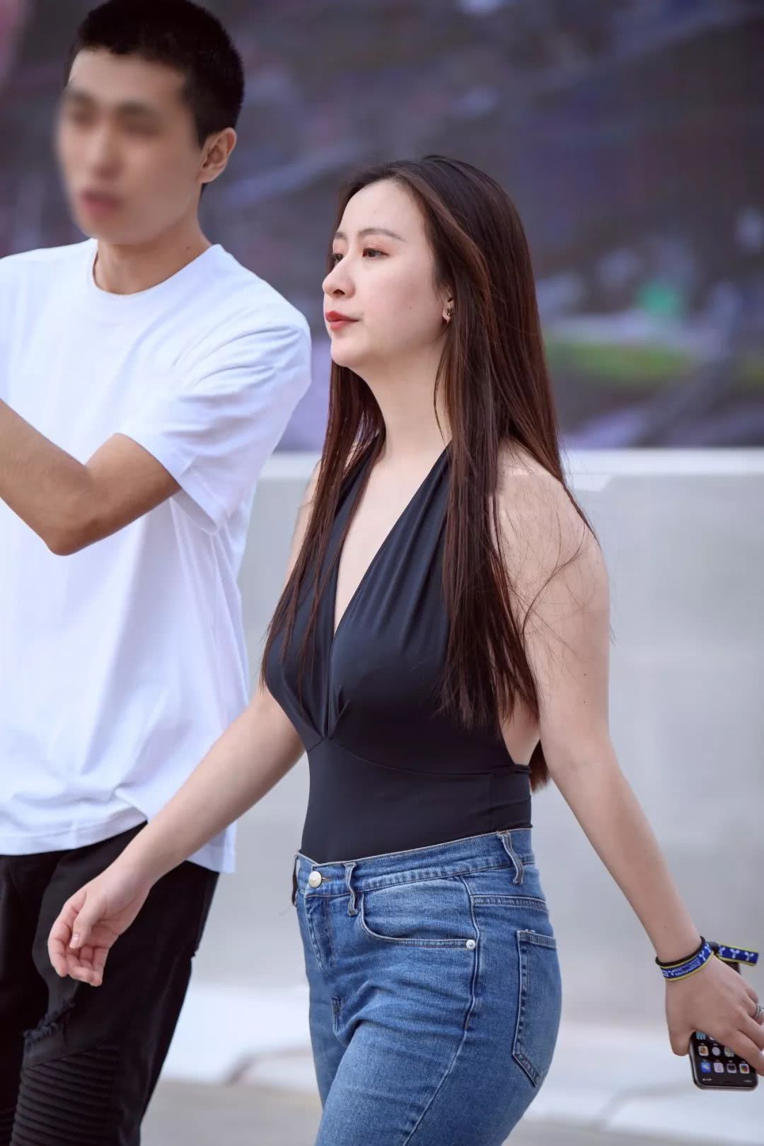 小姐姐黑色中开吊带搭配蓝色水洗牛仔裤，自信舞步风韵尚存