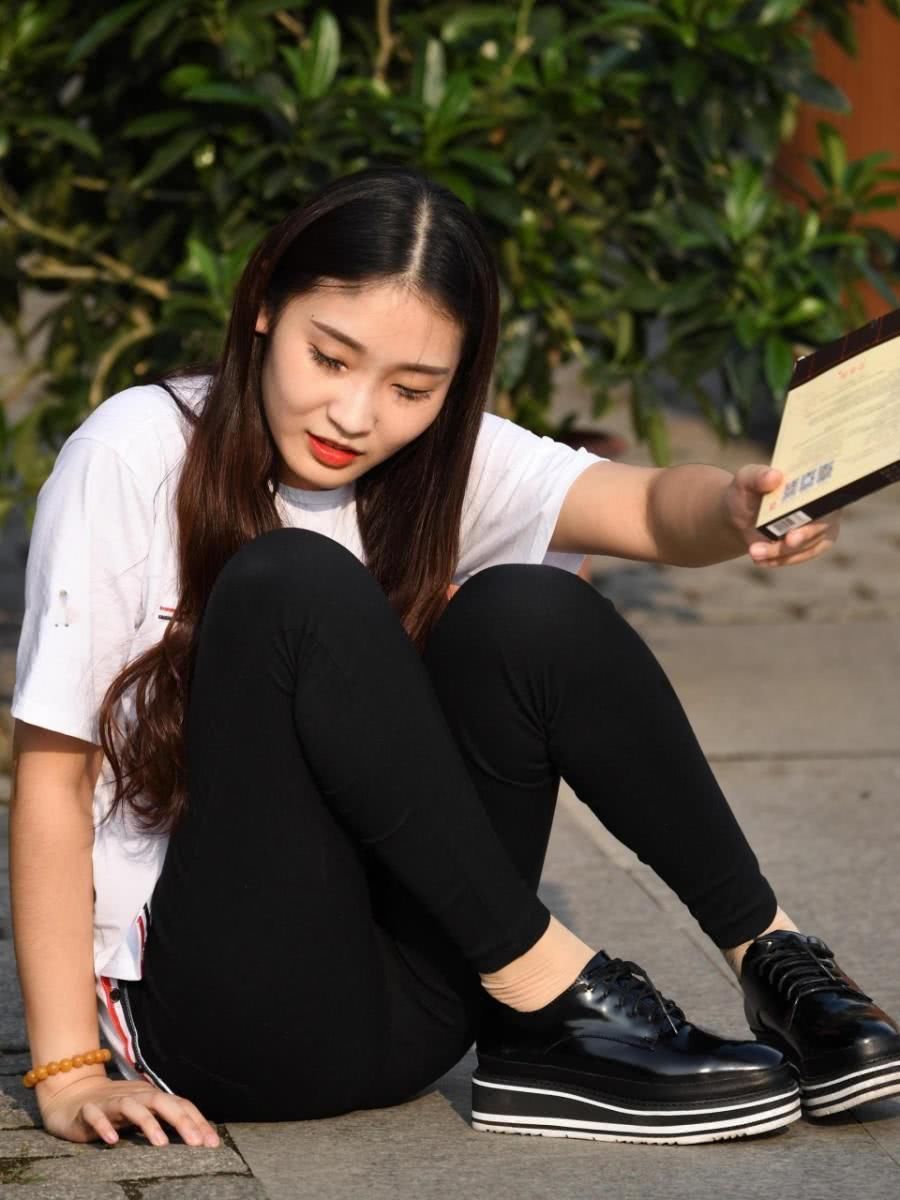 街拍:小姐姐盘腿坐在路边,紧身裤太紧绷,刚一起身差点儿没摔倒